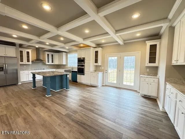 a large kitchen with stainless steel appliances kitchen island granite countertop a large cabinets a sink and a stove