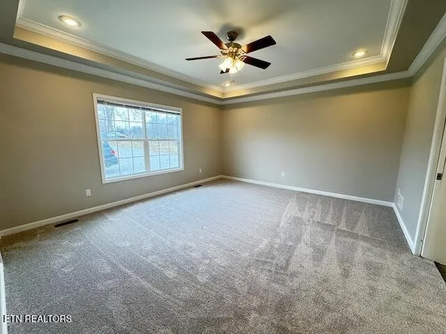 an empty room with windows and ceiling fan