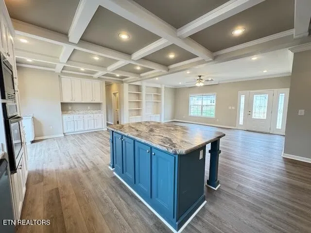 an open kitchen with a sink and wooden floor