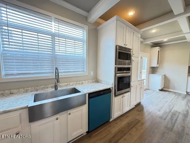 a kitchen with stainless steel appliances granite countertop a sink and a stove