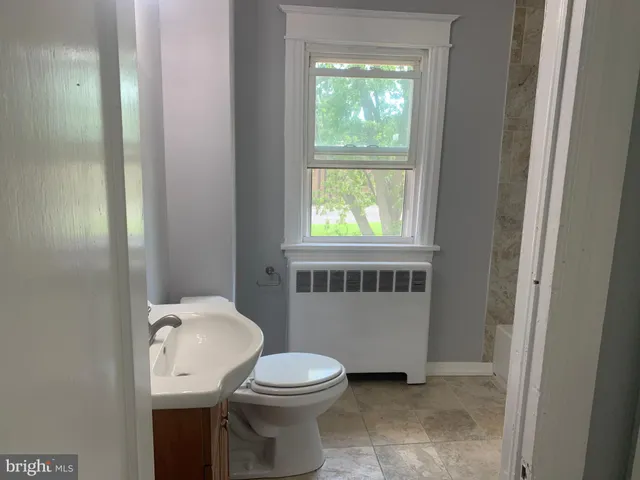 a bathroom with a toilet a sink and a window