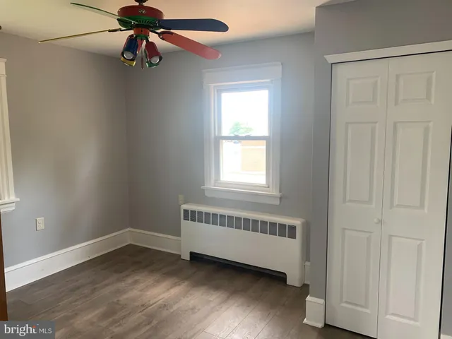 an empty room with a window and a ceiling fan