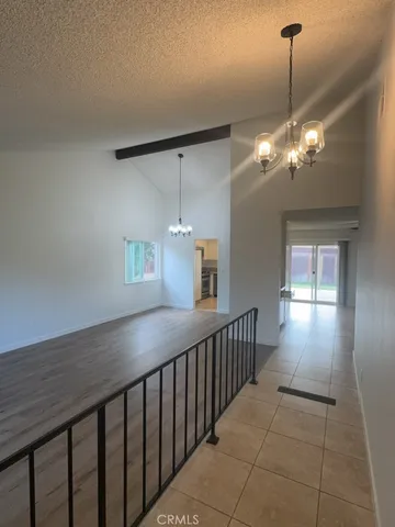 a view of a hallway with window and chandelier