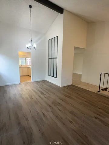 a view of empty room with wooden floor and window