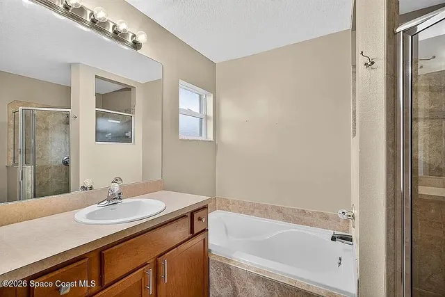 a bathroom with a granite countertop sink a mirror and a bathtub