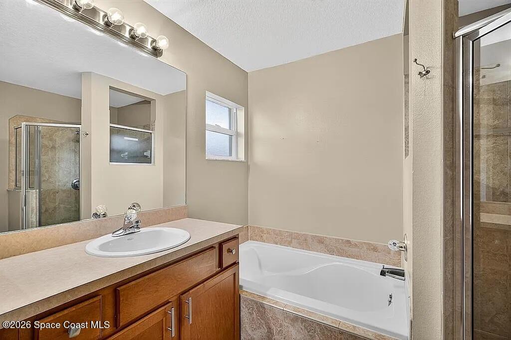 361 Del Monte Road, Unit B Sebastian, FL 32958 - Photo 13 of 23 a bathroom with a granite countertop sink a mirror and a bathtub