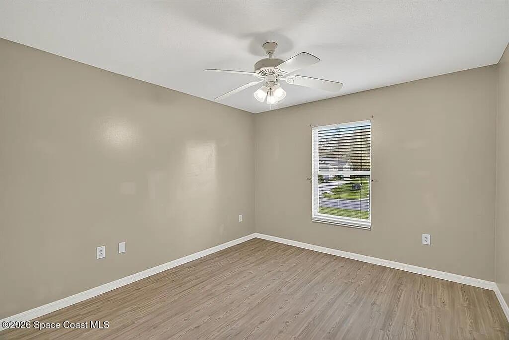 361 Del Monte Road, Unit B Sebastian, FL 32958 - Photo 15 of 23 an empty room with wooden floor fan and windows