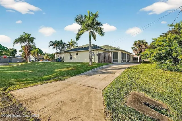 a front view of a house with a yard and potted plants