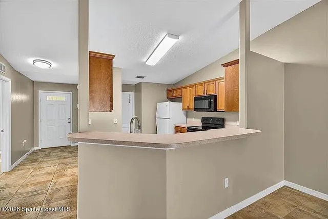 a kitchen with stainless steel appliances granite countertop a sink and a refrigerator