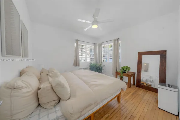 a spacious bedroom with a bed and wooden floor