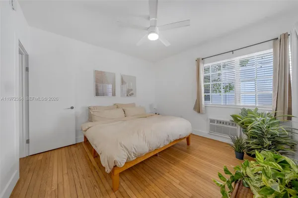 a spacious bedroom with a bed and a potted plant