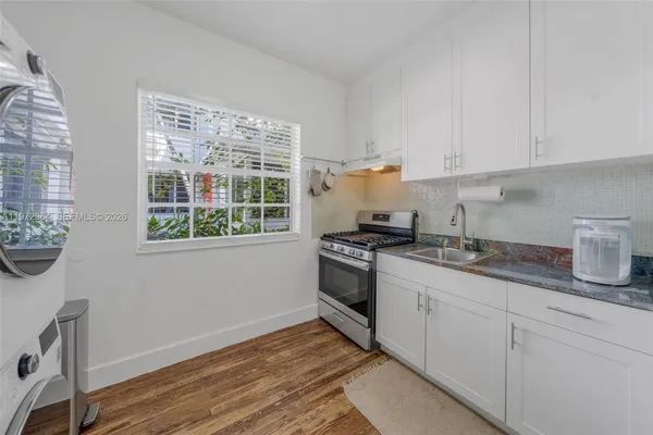 a kitchen with granite countertop white cabinets and white appliances