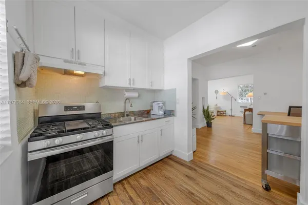 a kitchen with a stove and white cabinets