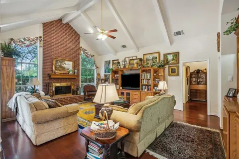 a living room with furniture kitchen view and a large window