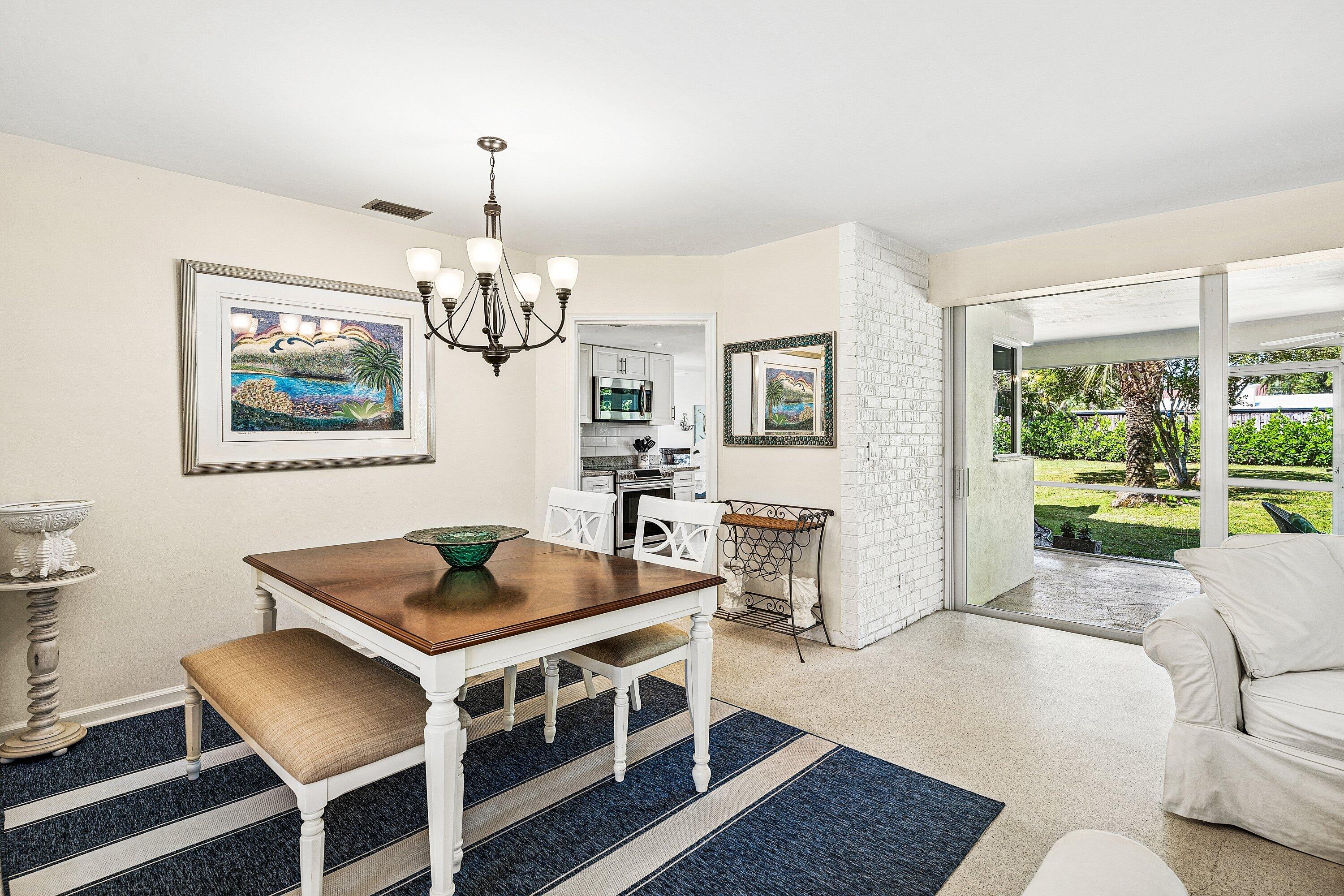 5550 Osprey Drive Ocean Ridge, FL 33435 - Photo 13 of 44 a living room with furniture a chandelier and a table