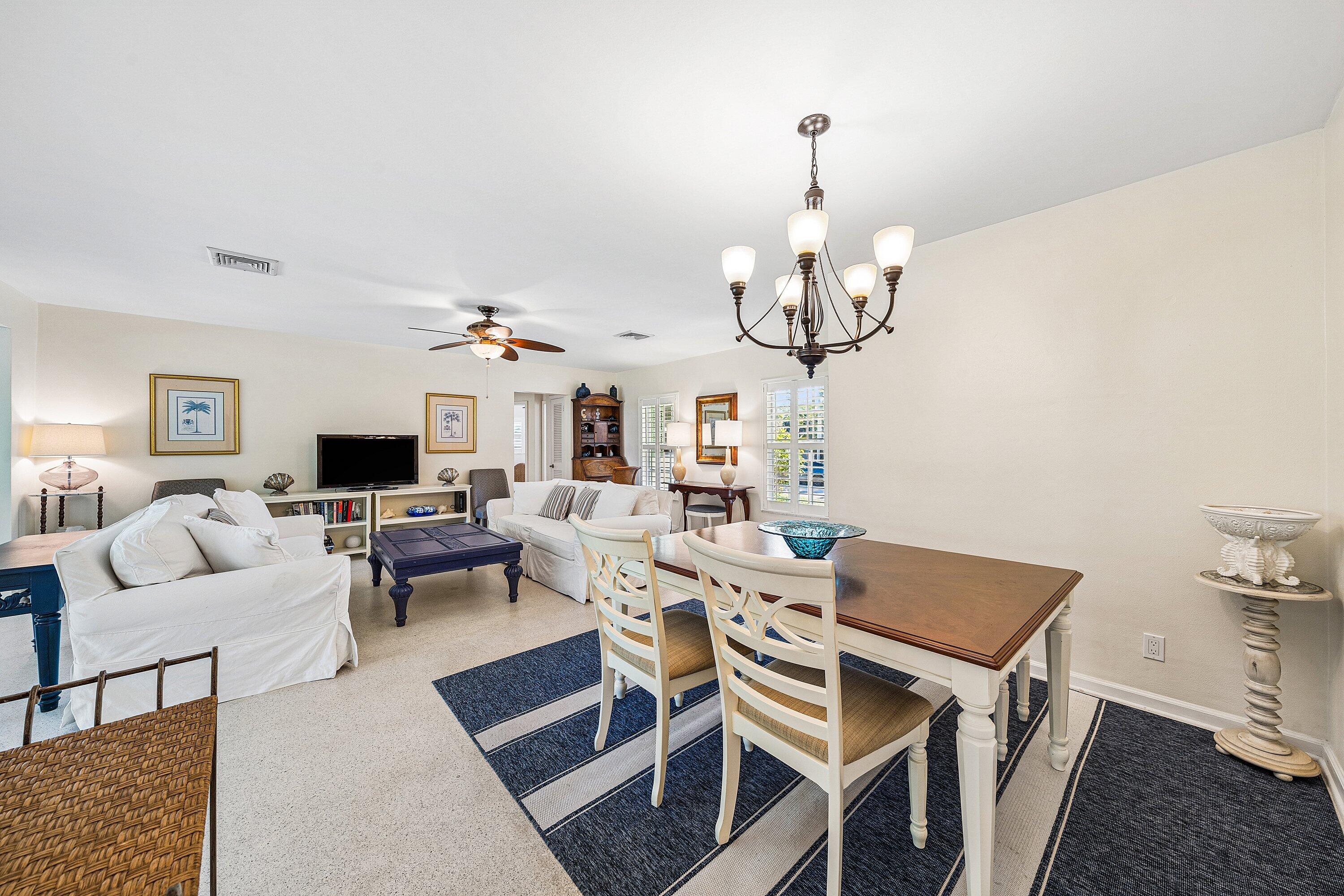 5550 Osprey Drive Ocean Ridge, FL 33435 - Photo 14 of 44 a dining room with wooden floor a chandelier a glass table and chairs