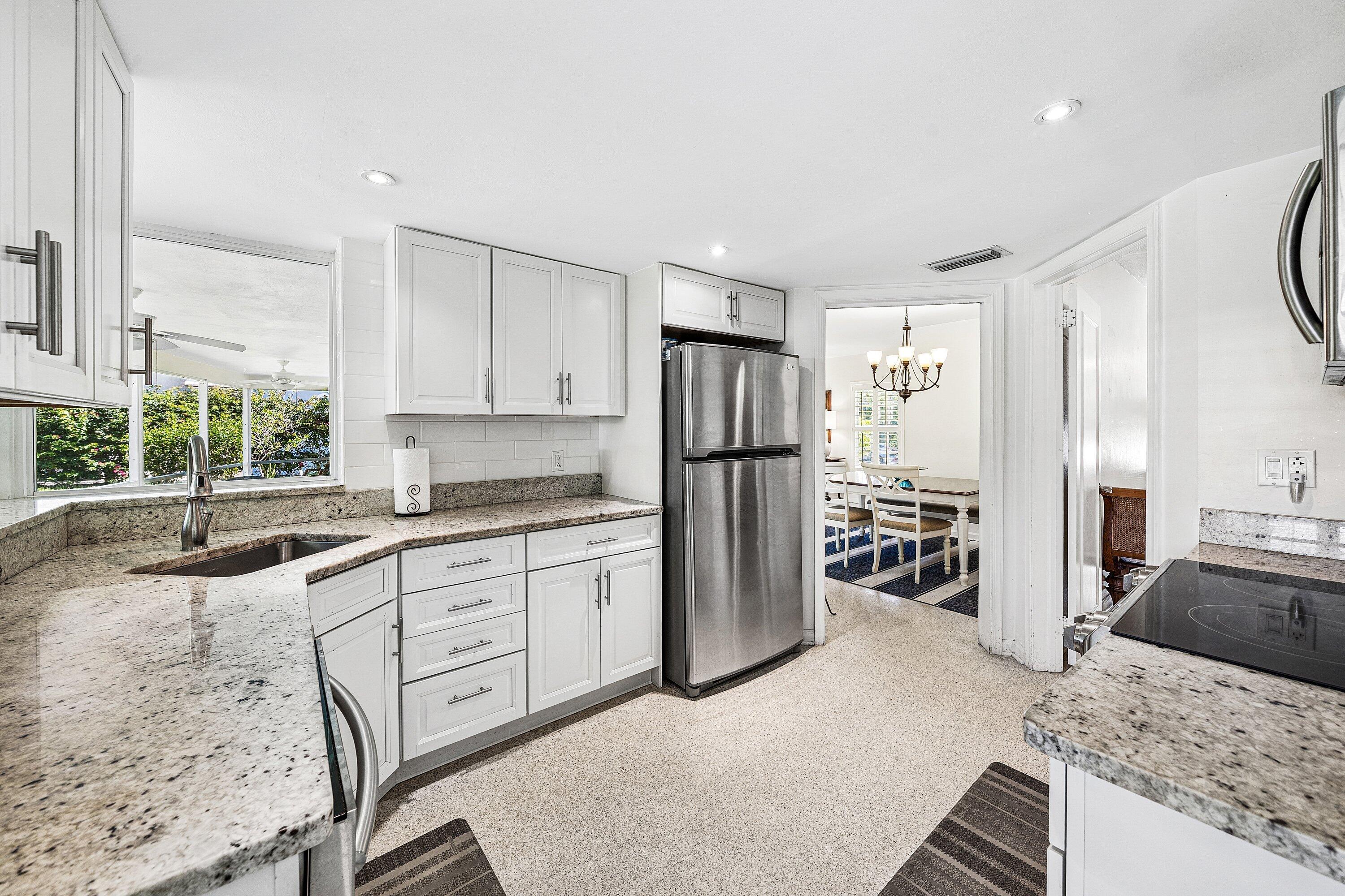 5550 Osprey Drive Ocean Ridge, FL 33435 - Photo 16 of 44 a kitchen with granite countertop a refrigerator and a sink