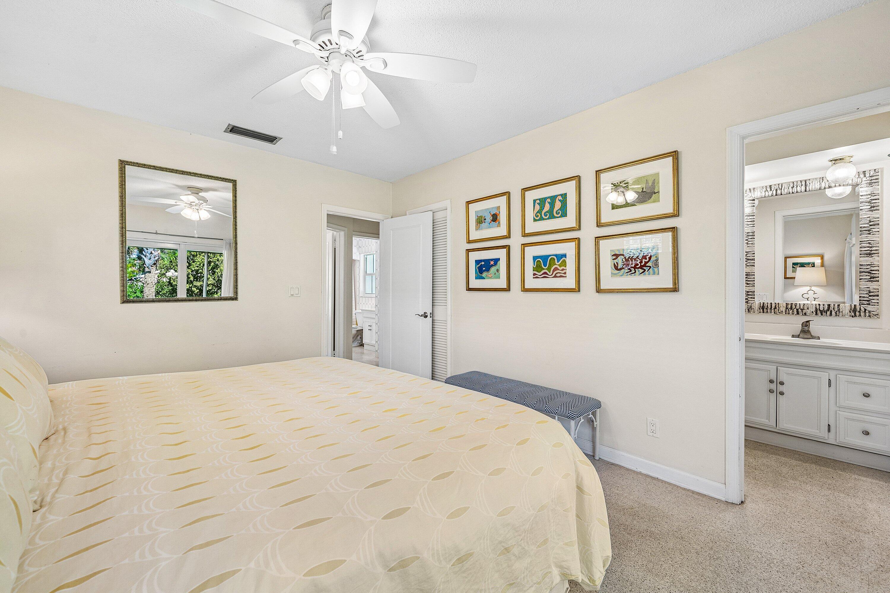 5550 Osprey Drive Ocean Ridge, FL 33435 - Photo 25 of 44 a bedroom with a large bed and a chandelier
