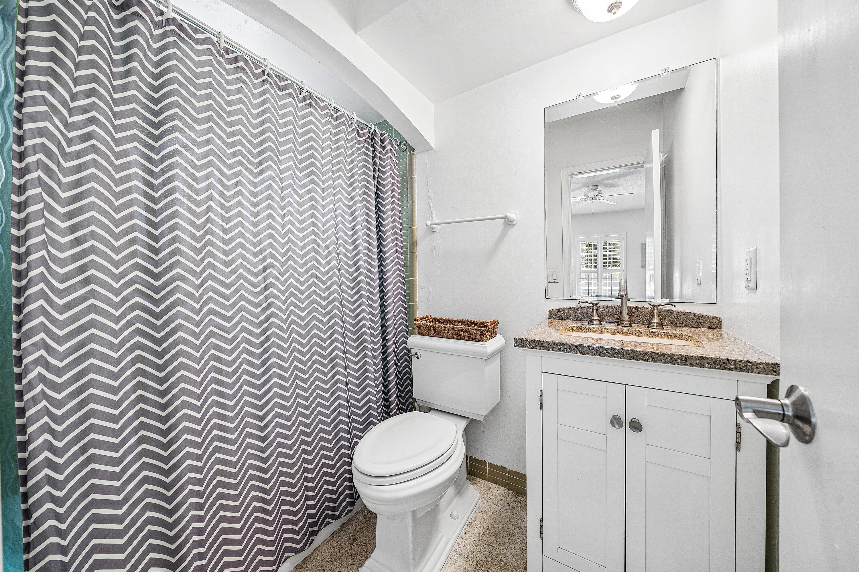 5550 Osprey Drive Ocean Ridge, FL 33435 - Photo 30 of 44 a bathroom with a granite countertop toilet a sink and mirror