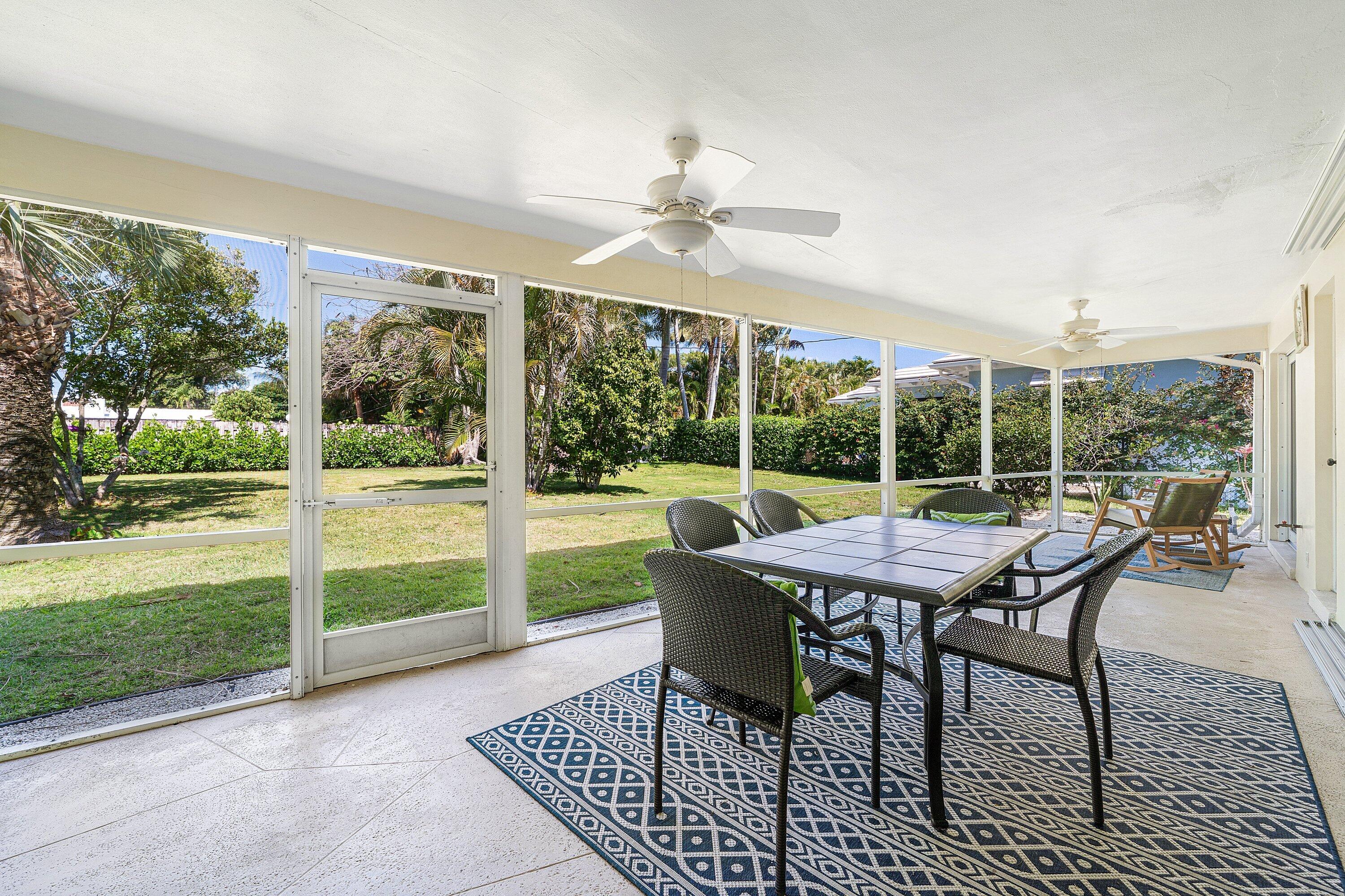 5550 Osprey Drive Ocean Ridge, FL 33435 - Photo 31 of 44 a table and chairs in front of a yard