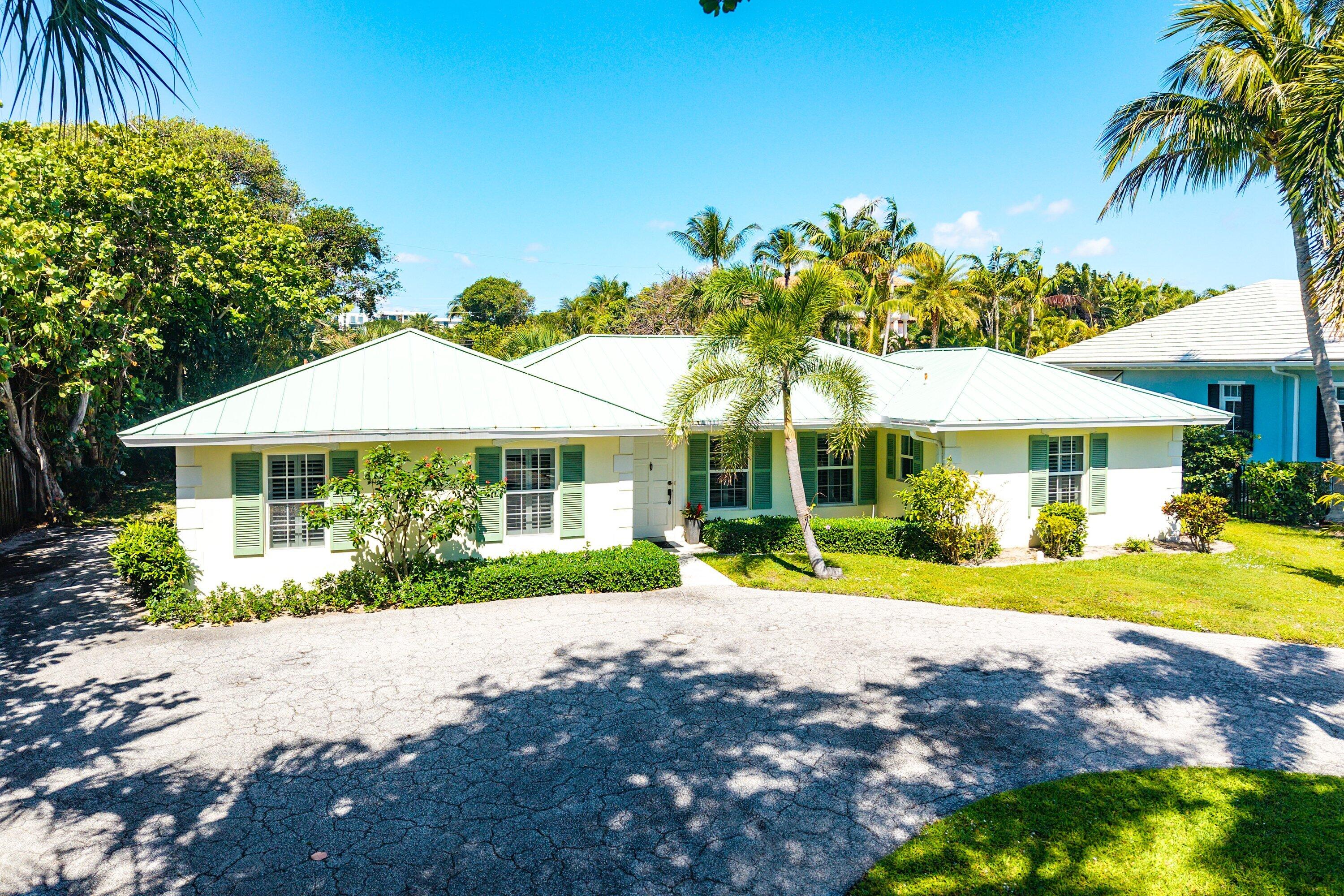 5550 Osprey Drive Ocean Ridge, FL 33435 - Photo 38 of 44 a front view of a house with a yard and potted plants