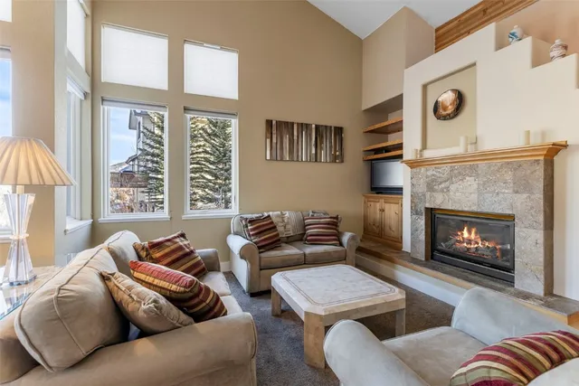 a living room with furniture a large window and a fireplace