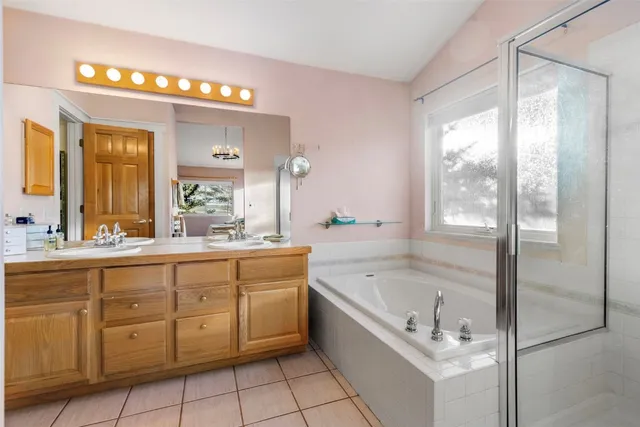 a spacious bathroom with a granite countertop sink mirror and bathtub