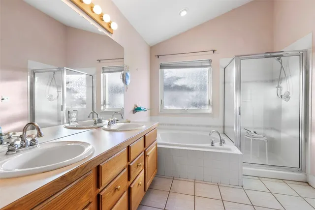 a bathroom with a tub sink shower and a mirror