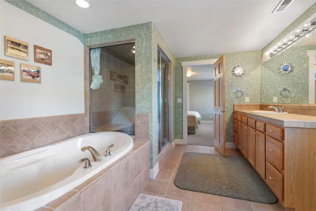 a bathroom with a tub sink and mirror