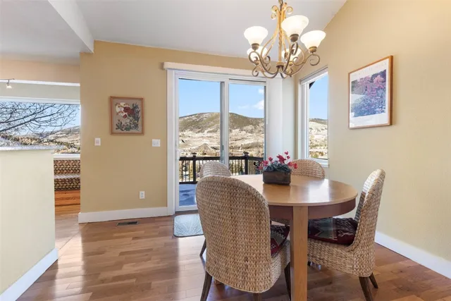 a view of a dining room with furniture a chandelier and wooden floor
