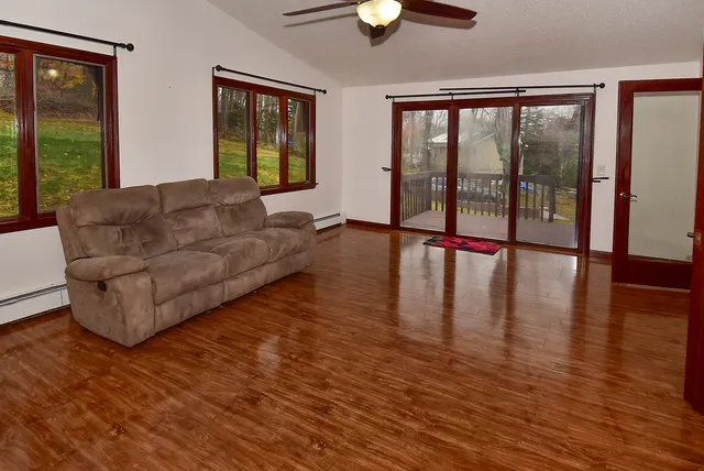 a living room with couches and a large window with wooden floor