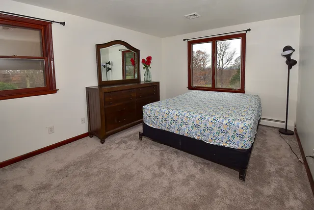 a bed sitting in a bedroom next to a window