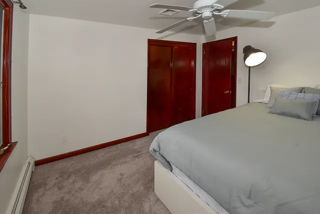 a bedroom with a bed and a chandelier fan