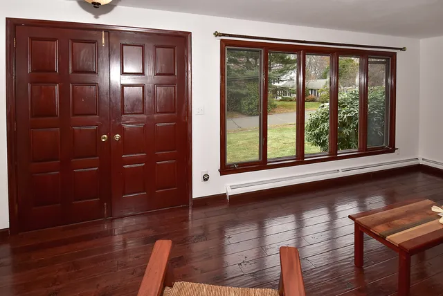 a view of a hallway with wooden floor and windows