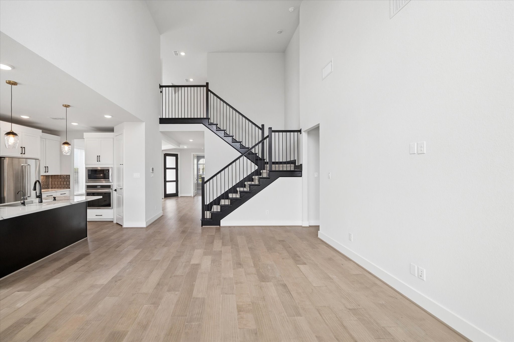 31435 Beacon Cove Trail Fulshear, TX 77441 - Photo 9 of 35 a view of a kitchen with wooden floor and a sink