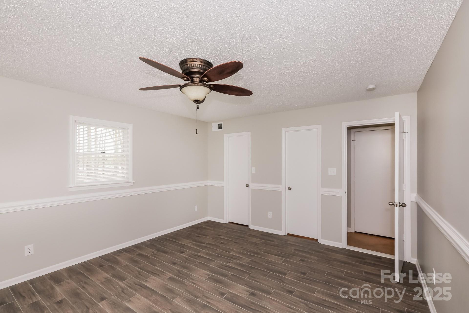 826 Potter Road Monroe, NC 28110 - Photo 11 of 17 a view of a big room with wooden floor and a ceiling fan