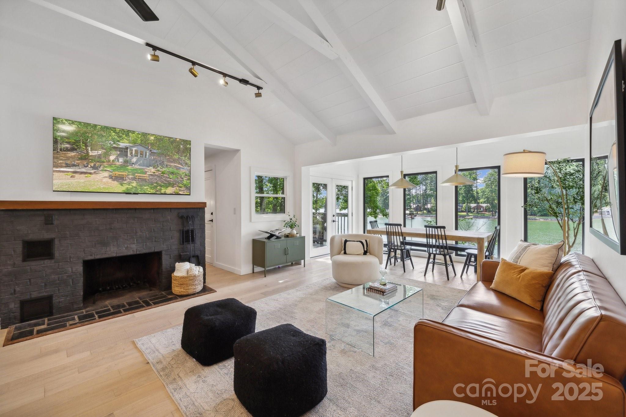 254 South Fork Road Mooresville, NC 28117 - Photo 2 of 34 a living room with furniture potted plant floor to ceiling window and a fireplace