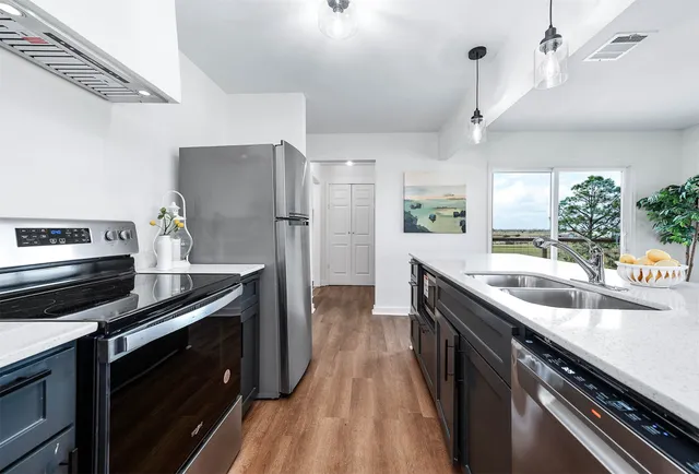 a kitchen with sink stove and refrigerator