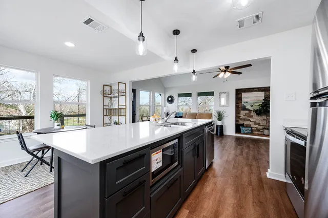 a large kitchen with stainless steel appliances granite countertop a large center island and a stove