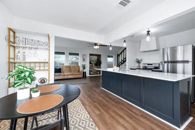 a kitchen with a table chairs sink and cabinets