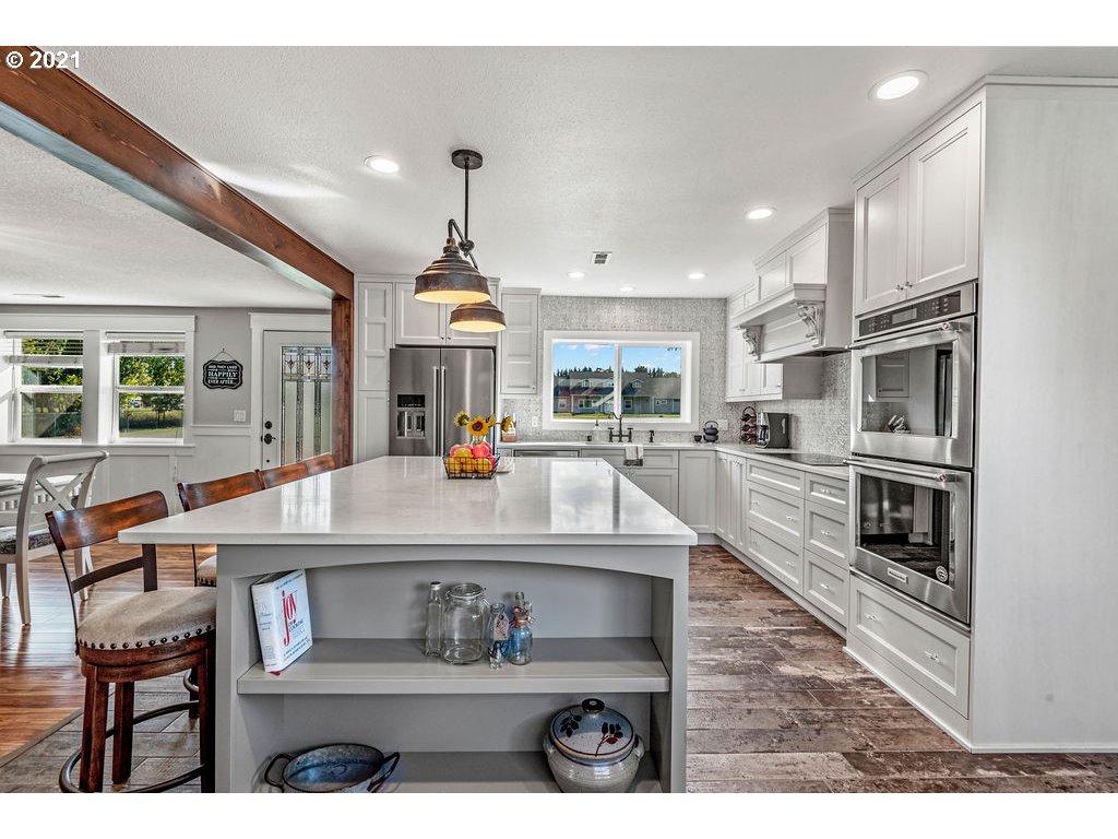 320 Northwest 194th Street Ridgefield, WA 98642 - Photo 11 of 32 a large kitchen with stainless steel appliances kitchen island granite countertop a large stove a sink and a refrigerator