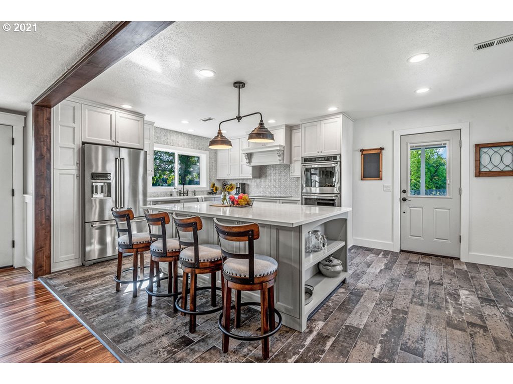 320 Northwest 194th Street Ridgefield, WA 98642 - Photo 15 of 32 a open kitchen with stainless steel appliances kitchen island granite countertop a table chairs and a refrigerator