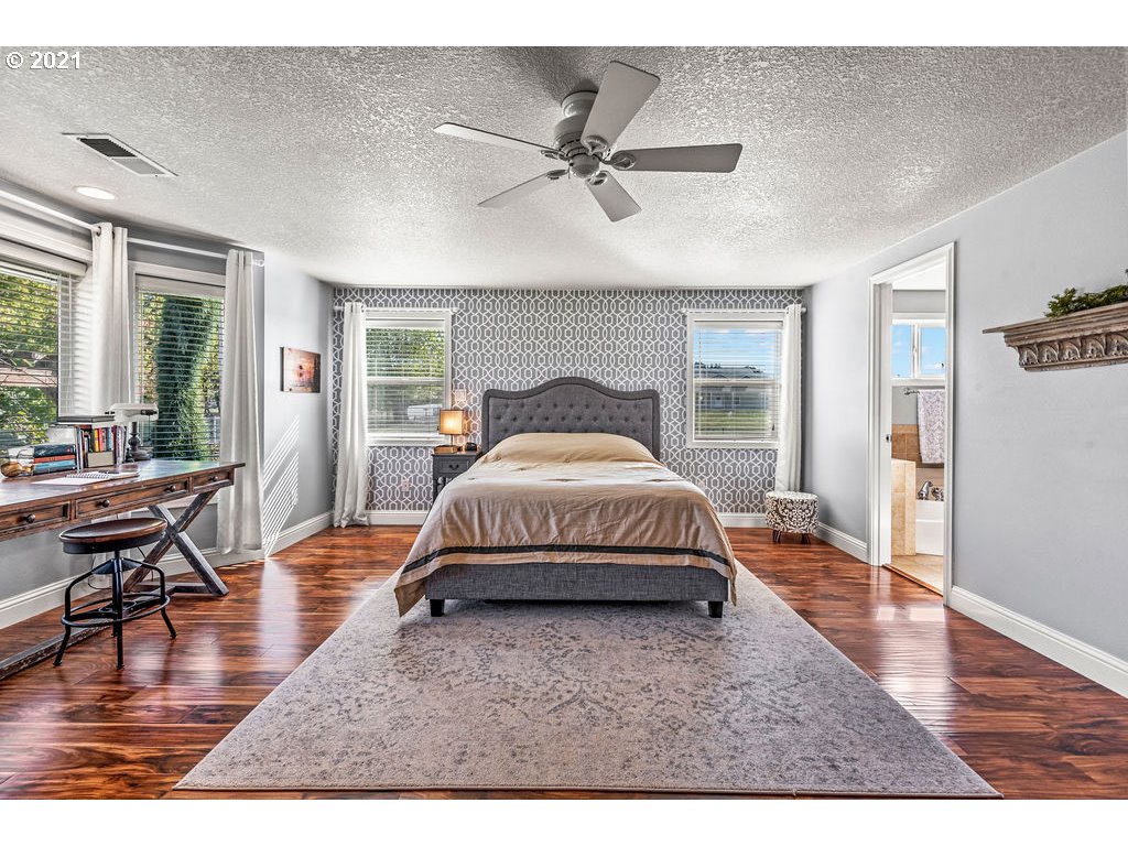 320 Northwest 194th Street Ridgefield, WA 98642 - Photo 21 of 32 a spacious bedroom with a bed a table and wooden floor