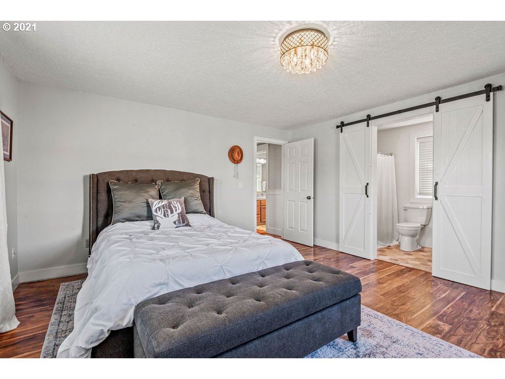 320 Northwest 194th Street Ridgefield, WA 98642 - Photo 26 of 32 a bedroom with a bed window and a chandelier
