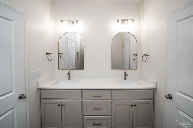 a bathroom with double vanity sinks and a mirror