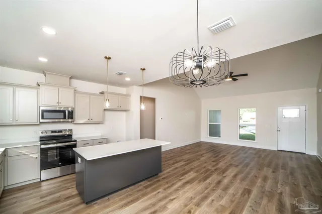 a large kitchen with kitchen island a sink stainless steel appliances and cabinets
