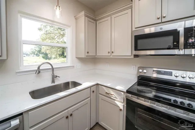a kitchen with a sink stove and microwave