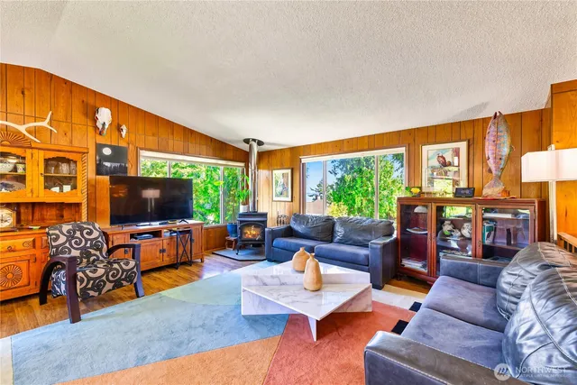a living room with furniture a flat screen tv and a large window