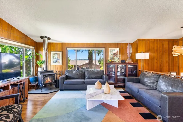 a living room with furniture a flat screen tv and a large window