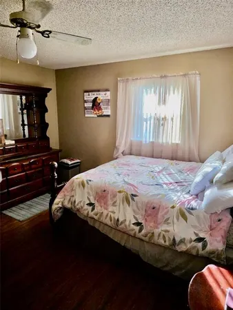 a bedroom with a bed dresser and a window